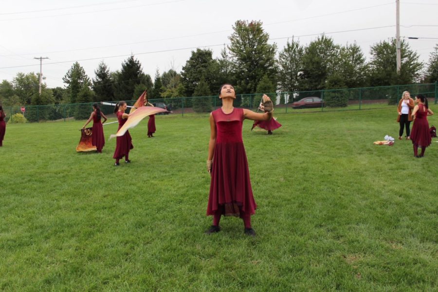 Color Guard captain Jen Chang tosses her rifle and holds her position to catch it. 
