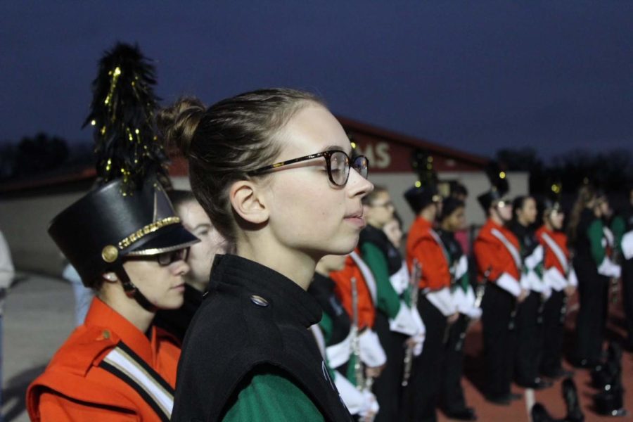 Piccolo player Cecilia Weaver takes a moment to take in the sounds of a Friday night football game.

