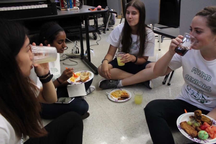 (from left) Amy Ouyang, Alexis Gordon, Rebekah Varghese and Samantha Haas eat the Friday food prepared by the band parents.
