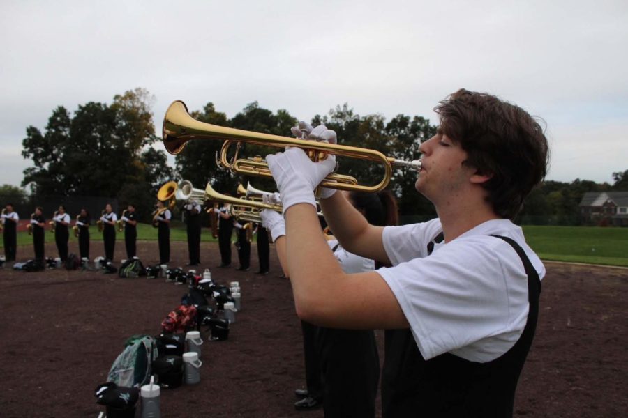 Trumpet player Rocco Cavallo warms up by blowing counted air through his instrument.
