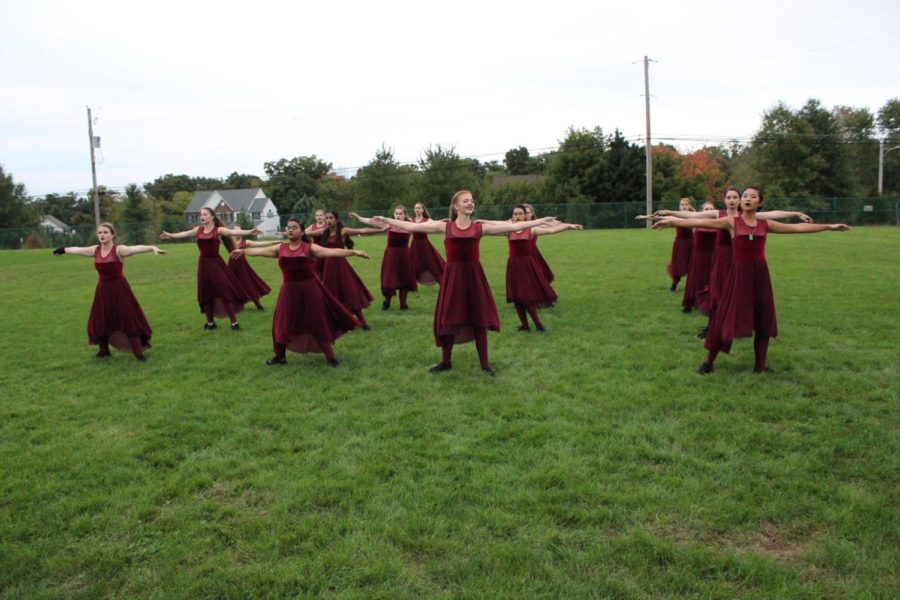 The color guard warms up with their across-the-field body exercise.
