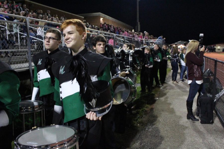 The band walks to the bleachers after playing the National Anthem.
