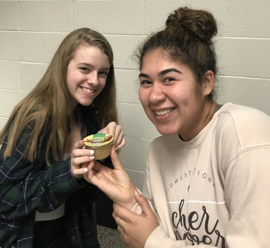 Sophomores Anna Troemel and Simone Robinson share an apple sauce during A lunch.
