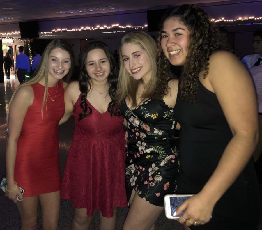 Four sophomore friends show off their fashion choices of black and red dresses. 
