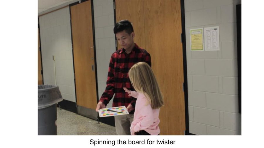 A club member holds the Twister spinner for one of the kids.