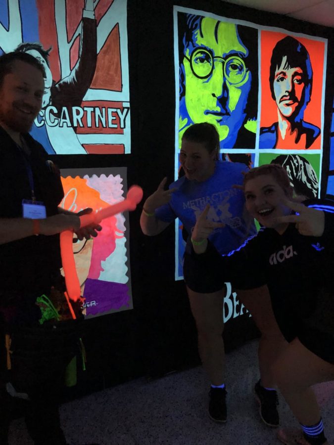 Lauren McDonald and Katherine Mcgrath pose with the balloon artist in the “blacklight hallway”. 
