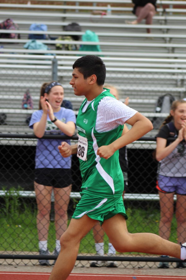 Sophomore Javier Altimirano ran while the girls lacrosse team cheered him on.