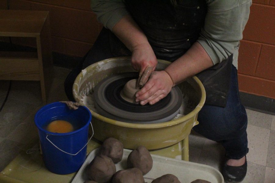In the second step, the artist must mold the clay into a bun shape. Next she pokes a hole into its center, spreads out the clay and then erects walls.
