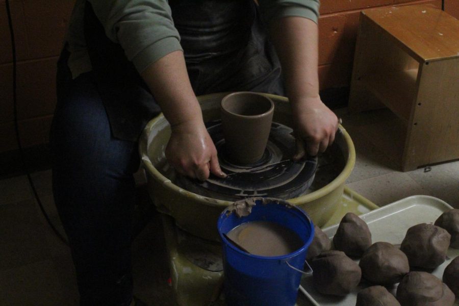 Before placing the clay into the kelm for glazing, Ms.Mcauley removes the excess from the bottom of the mug. 
