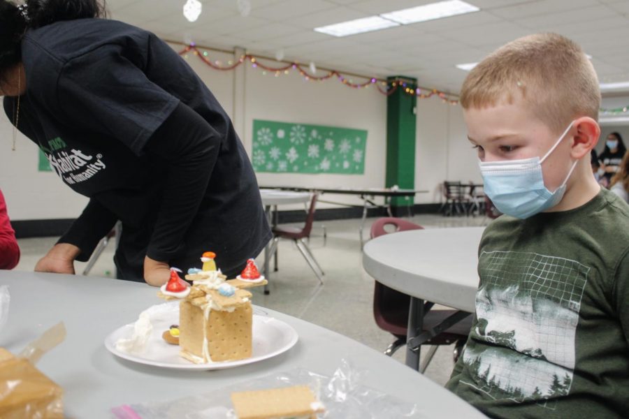 A little boy observes his gingerbread space creation.
