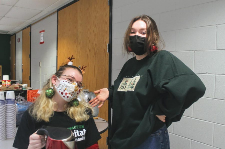 Sophia Musi and Sam Fishburn wear their festive attire while working the hot chocolate station.
