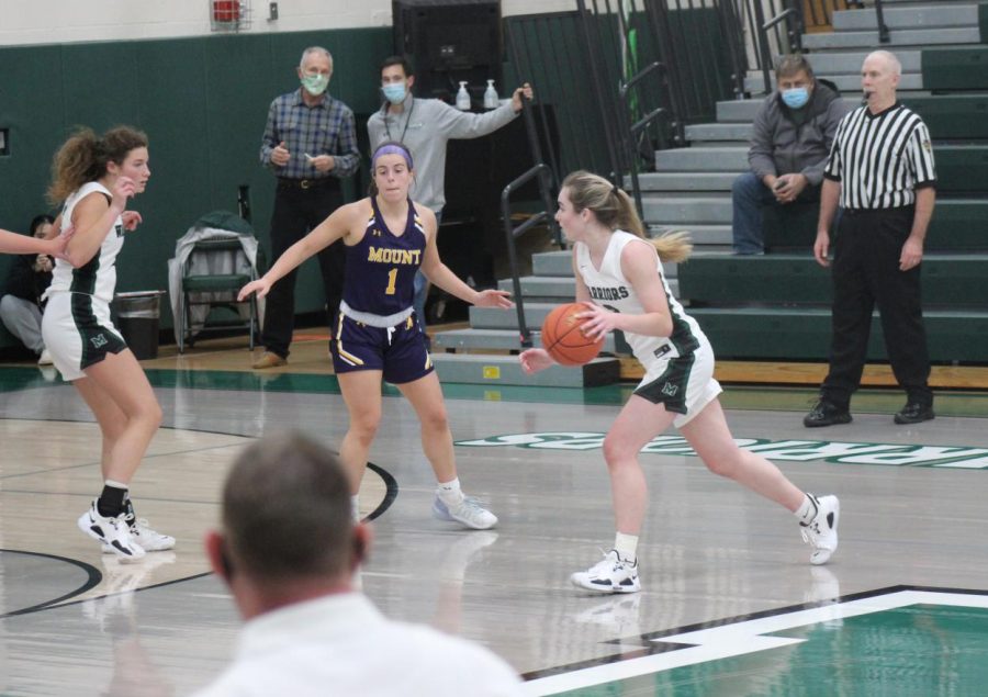 Point guard Cassidy Kropp moves to her left while head coach Craig Kaminiski watches on.