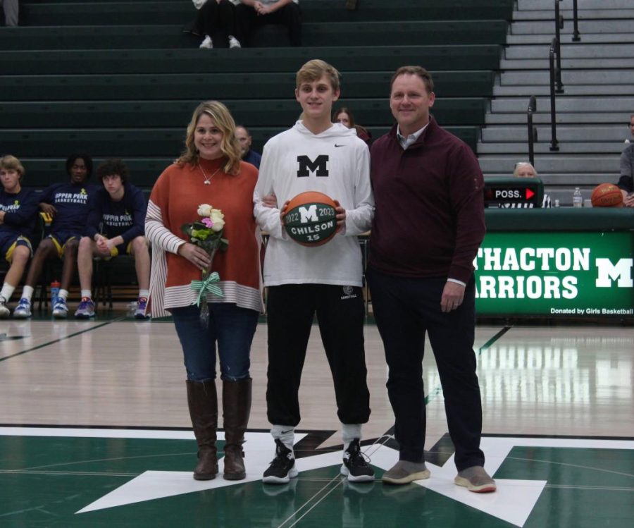 Senior Cam Chilson stands with his parents before the game. He plans on going to college for computer science or mathematics.
