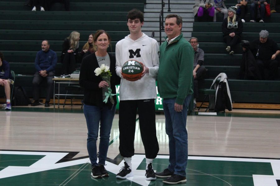 Senior Matt Christian stops at center court with his parents during the pre-game celebration. He plans to go to Kings College to play basketball.
