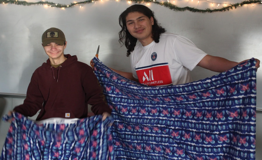 (from right) Yusuf Zabun and Dominic Layfield hold up their nearly finished blankets. 