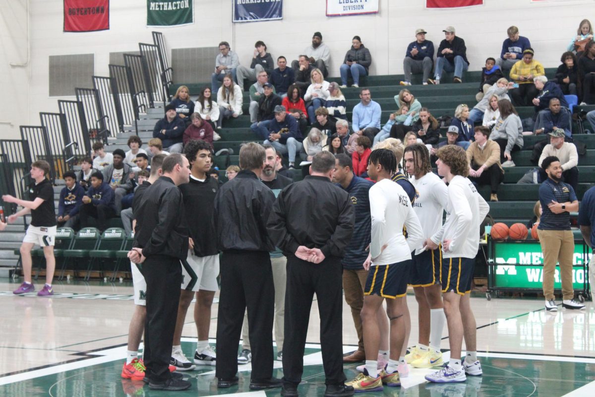 Captain Sal Iemmello and Wes Robinson listen to pre-game instructions from the referees at mid court minutes before the start of the game. 
