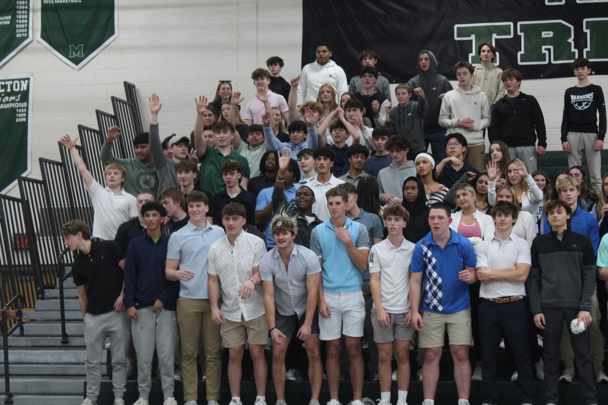 The Tribe stands in their country club gear trying to catch Methacton T-shirts from the sling shot. 
