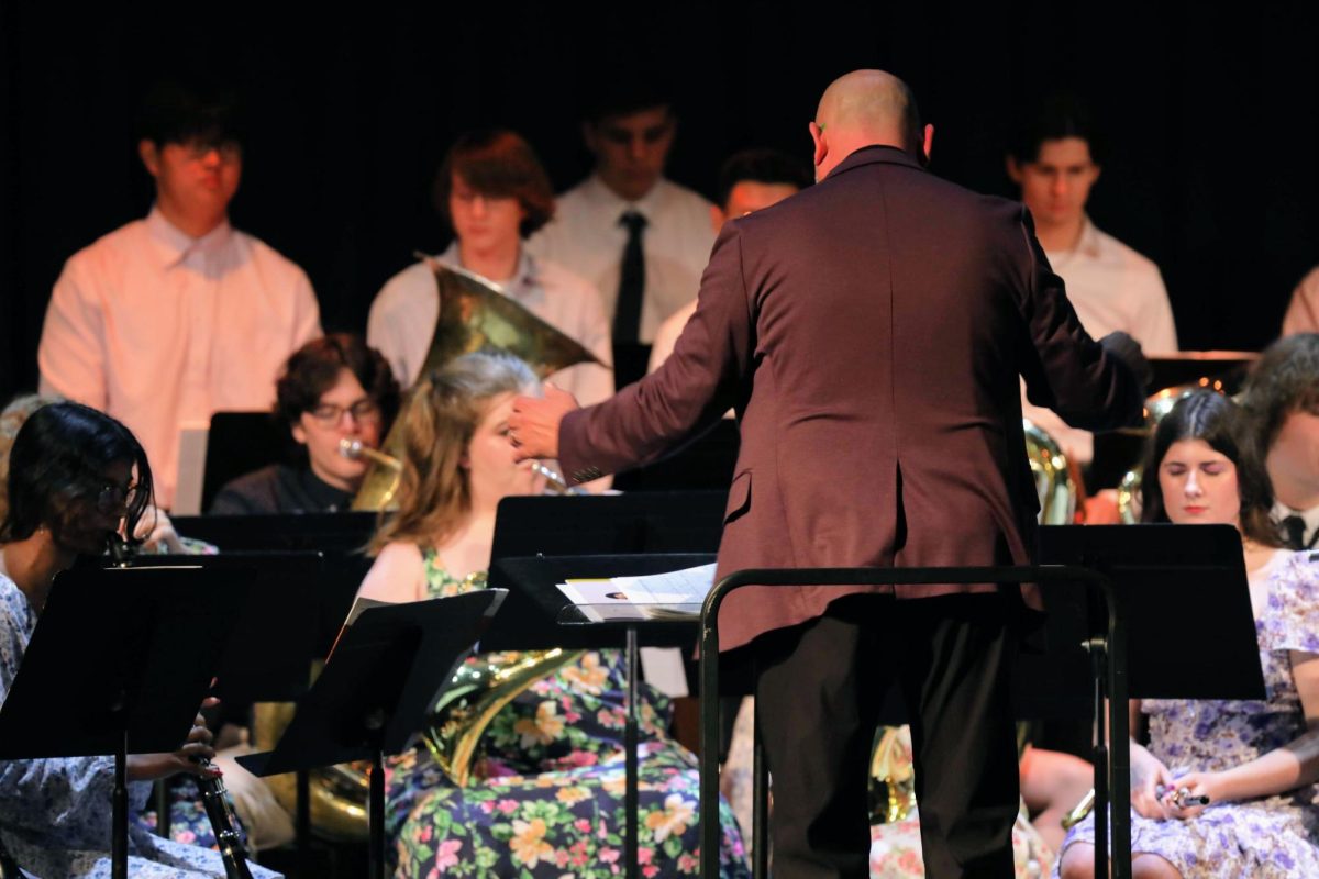 Mr. Jeffrey McCoach directs the concert band during the Aladdin medley on May 22, the group's final gathering of the school year. 